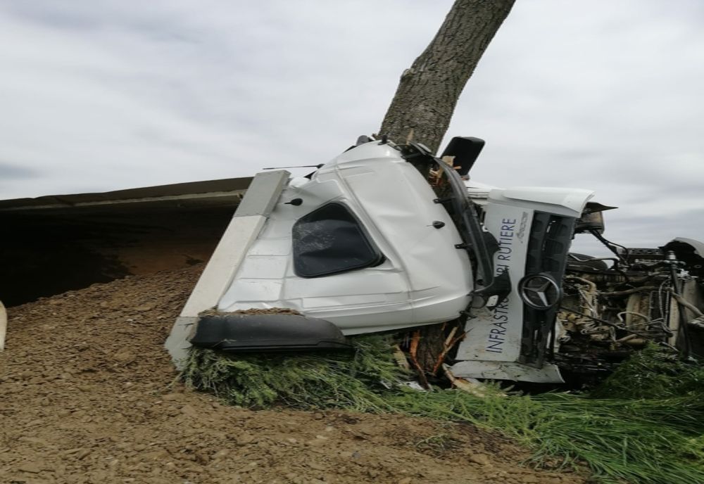 FOTO- Camion încărcat cu piatră, răsturnat în afara părții carosabile